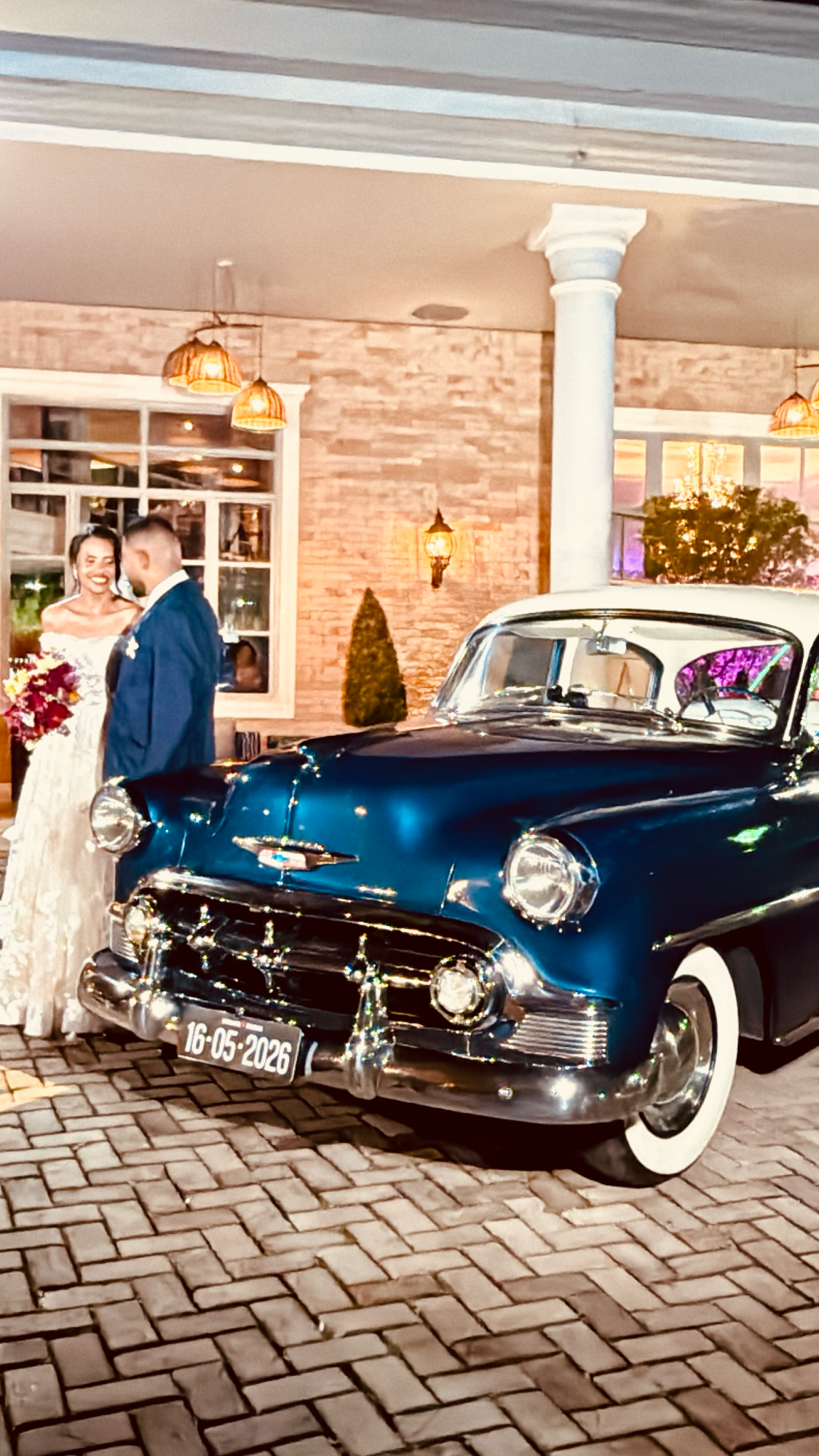 Noivos ao lado do Chevrolet Bel Air azul da ABM Locações